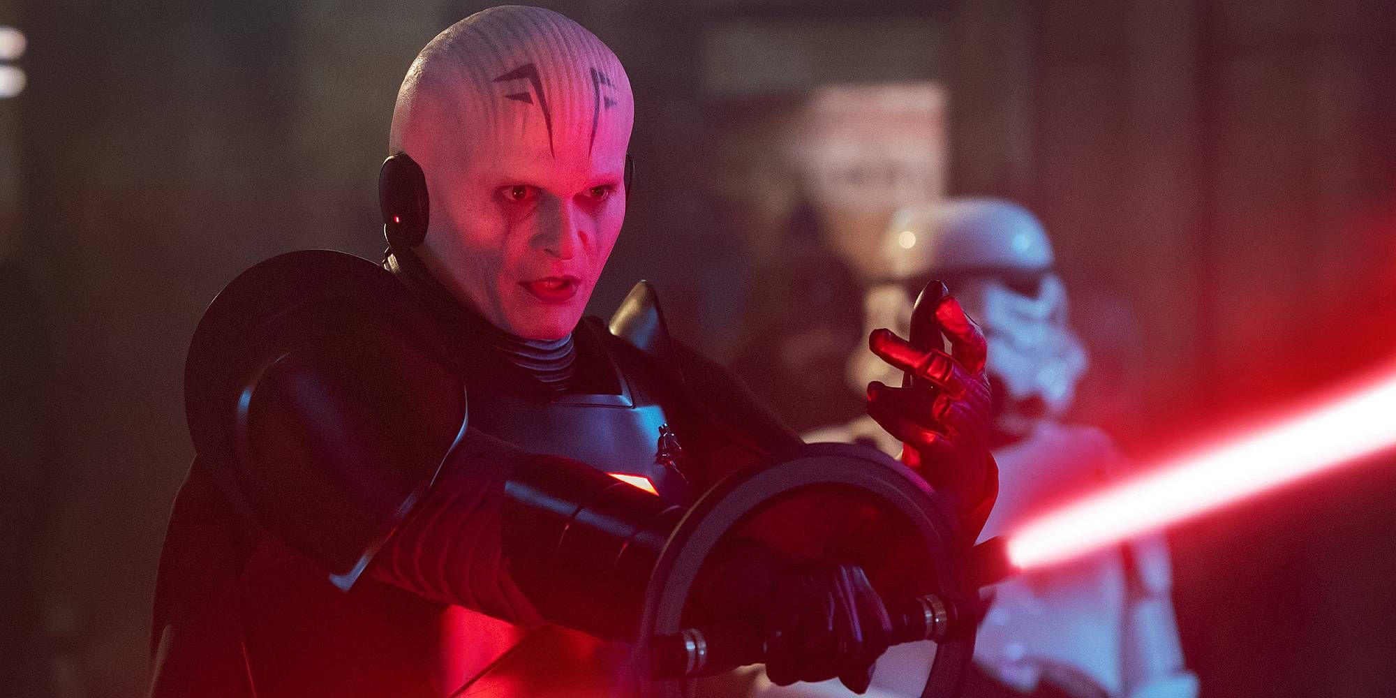 The Grand Inquisitor stands holding a red lightsaber