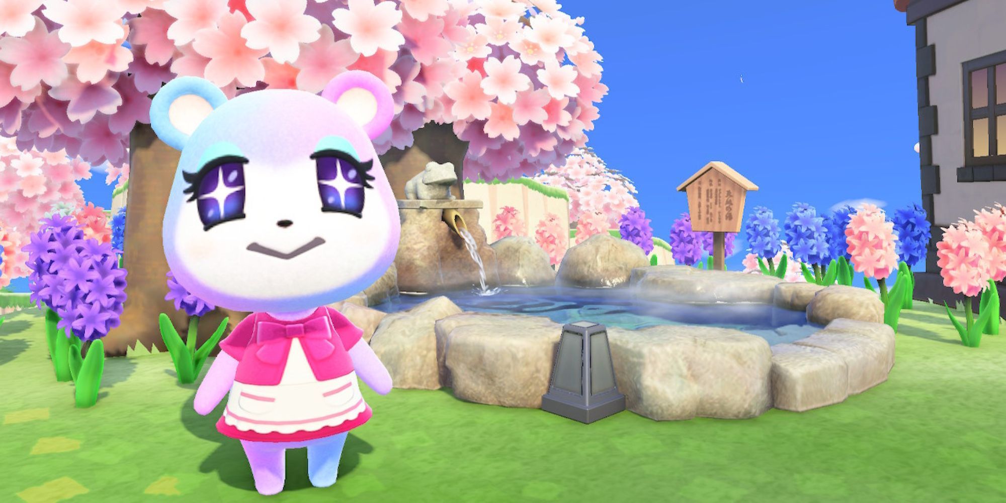 Judy stands by a pond beneath a cherry-blossom tree