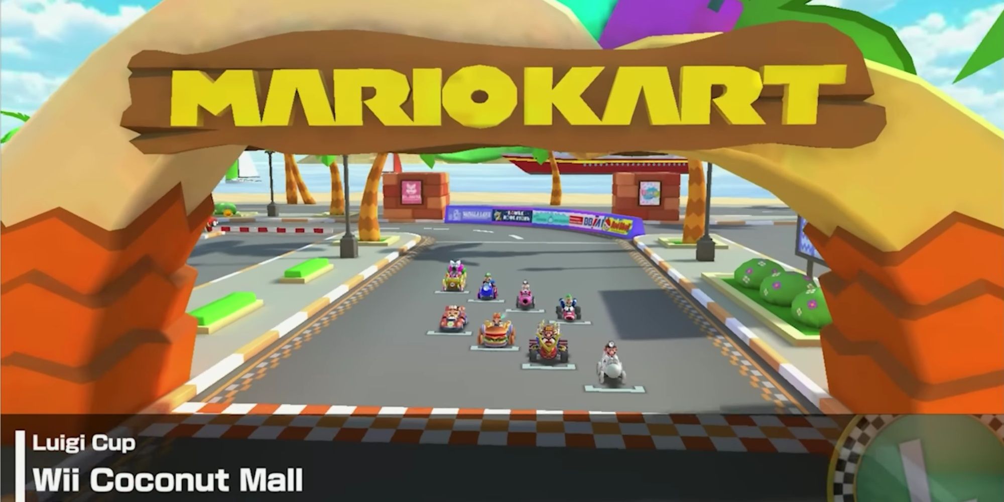 Screenshot from the opening of the race on the Wii track Coconut Mall with all racers lined up in the mobile Mario Kart Tour version.