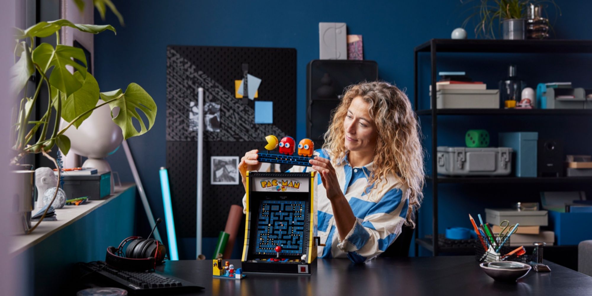 woman building a lego pac-man arcade cabinet