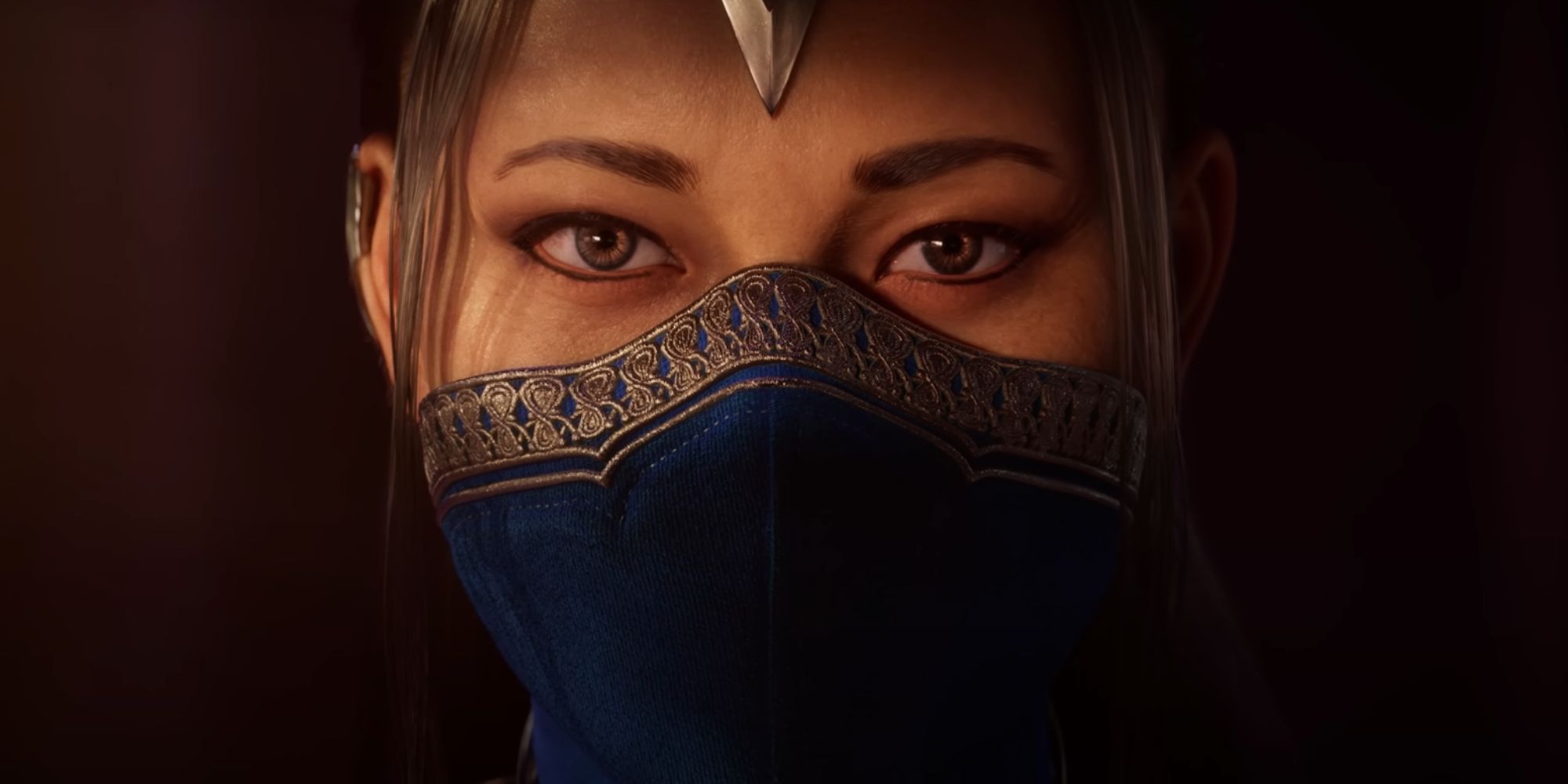 A close up of Kitana in the Mortal Kombat 1 trailer, looking at the camera and wearing a blue face covering.