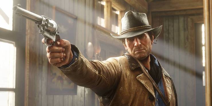 Red Dead Redemption 2 - Arthur Morgan looks ahead as he aims his revolver in a sunny interior