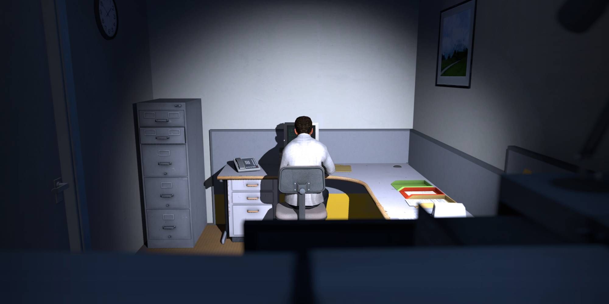 A man in a white office shirt is sitting in a dim office at a desk in The Stanley Parable