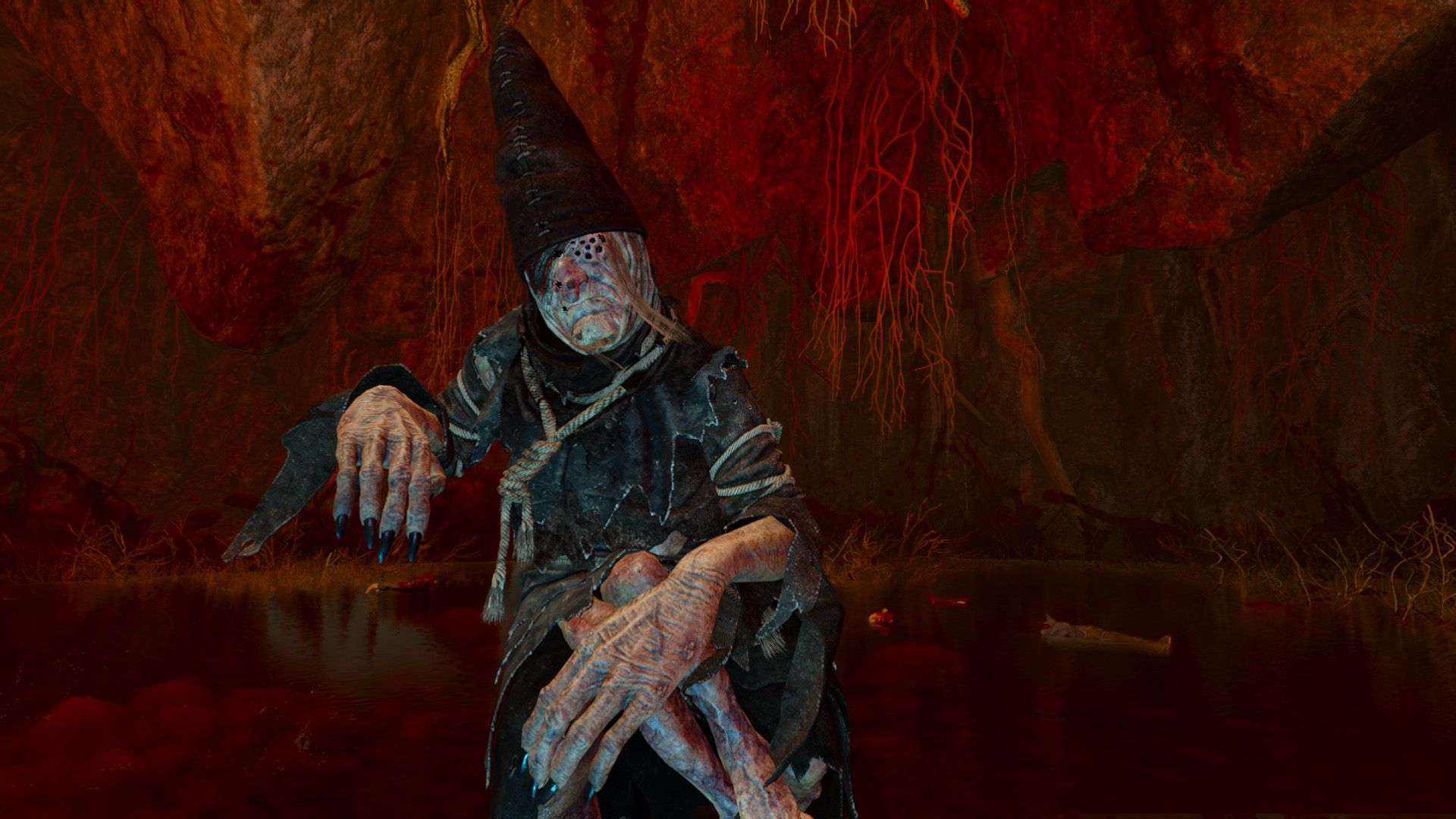 A monstrously deformed woman with tattered clothes walks through a bloody cavern.
