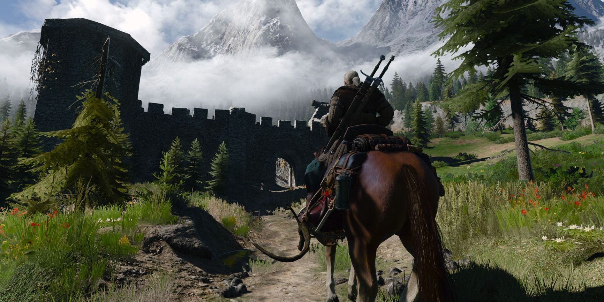 Geralt rides toward an old fortification in Kaer Morhen's valley in The Witcher 3.