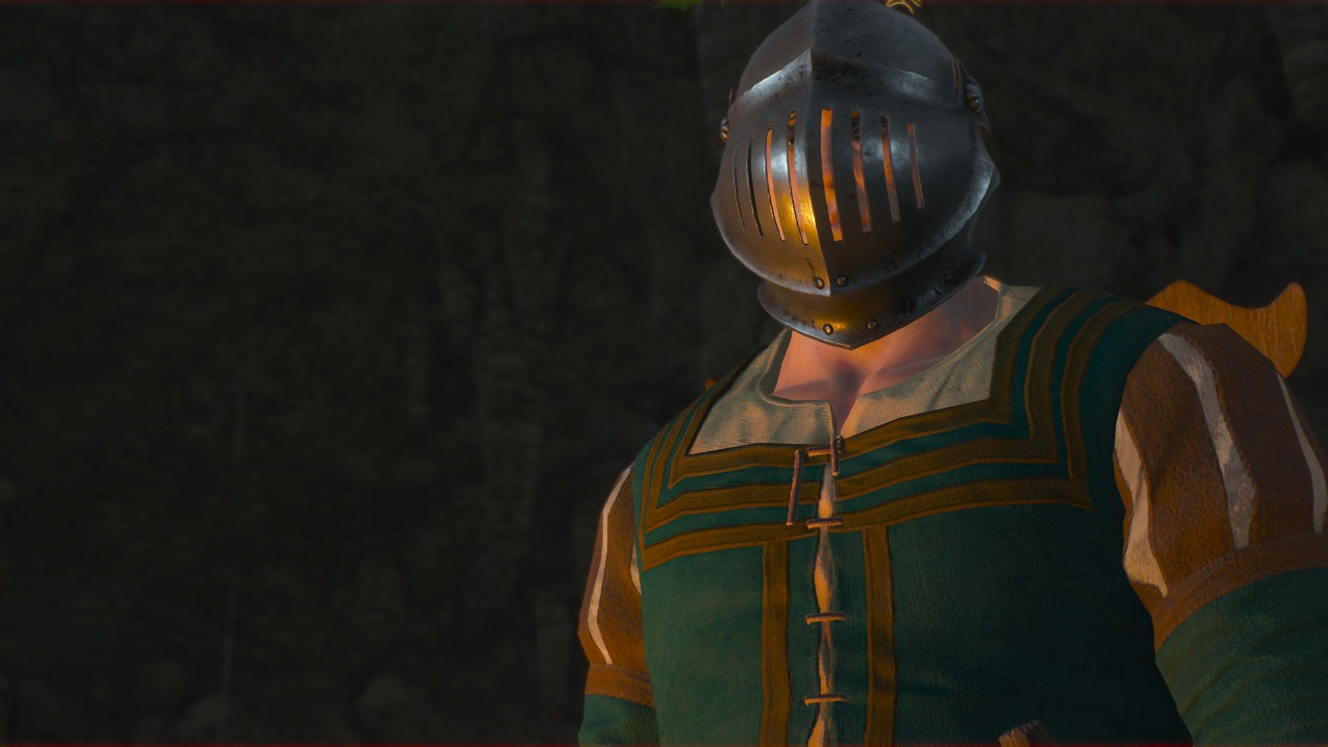 A man wearing expensive clothes and a full-face helmet stands in a dark cave.