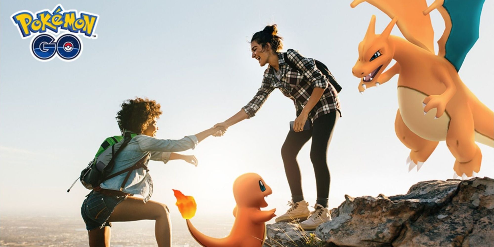 Pokemon Go promo photo of two people on a cliff with Charmander and Charizard.