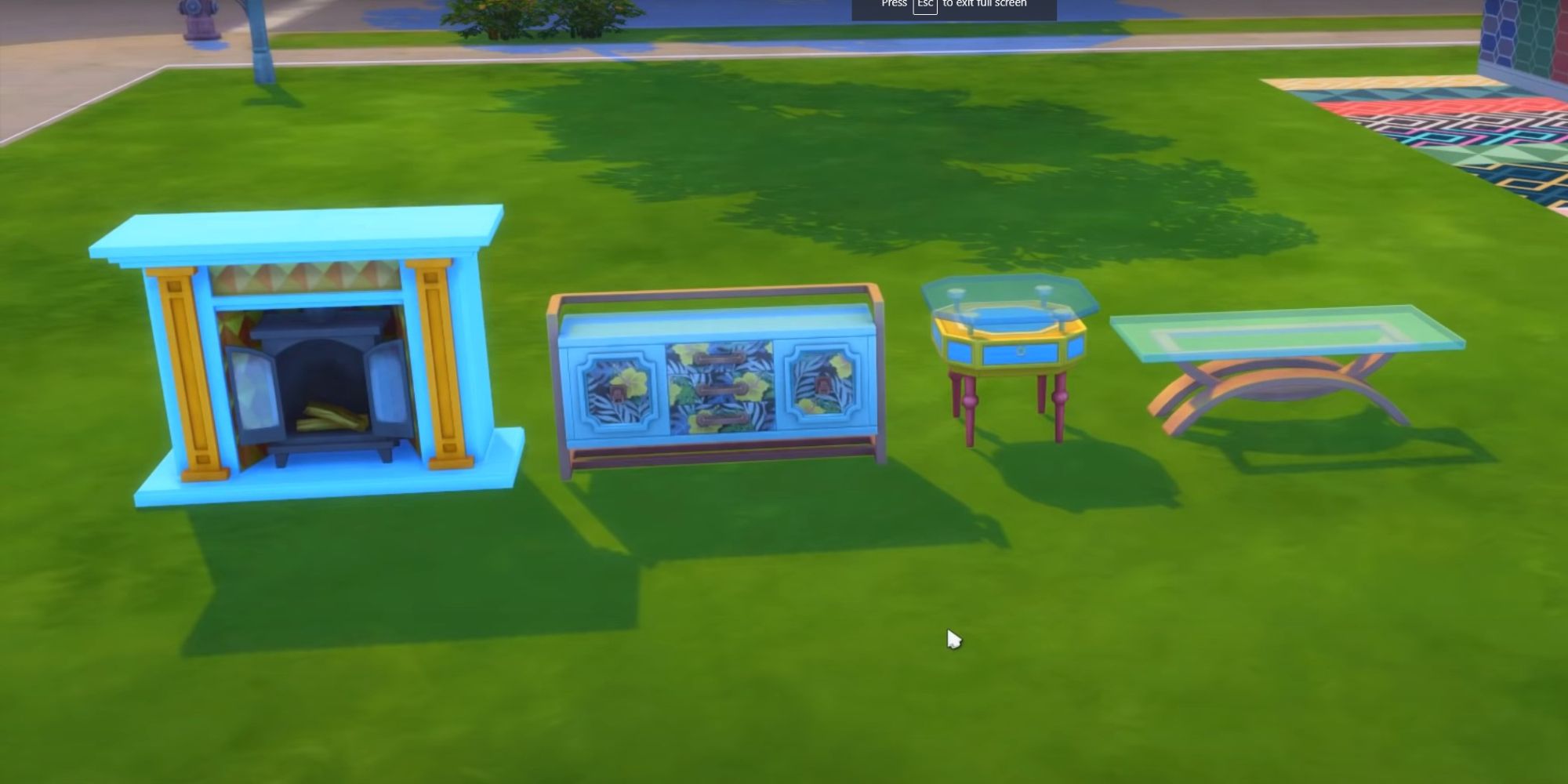 An image from the Sims 4 Decor To The Max Kit showing the four different surfaces added to the pack.  This photo shows a fireplace, side table, coffee table and console table in a blue pattern.