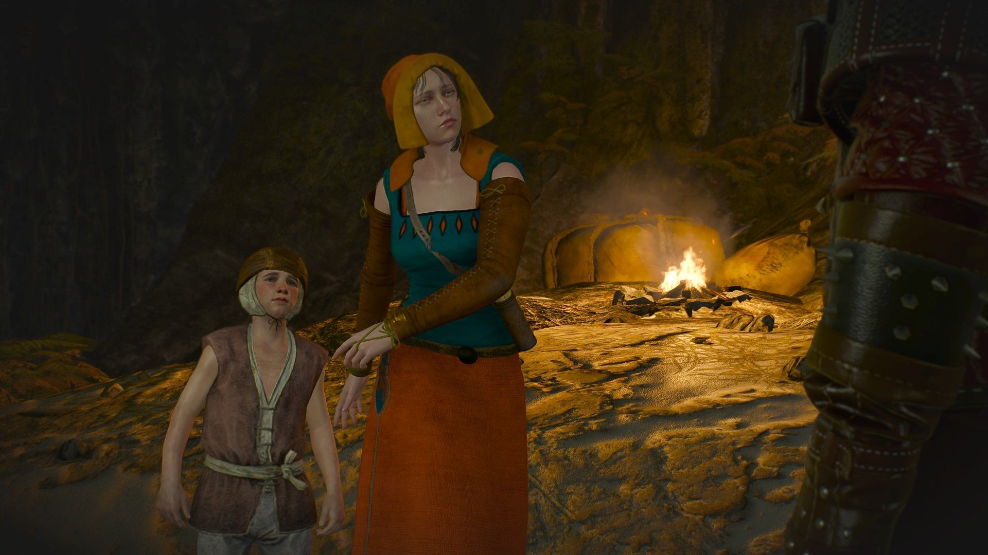 A woman shields her child from Geralt as he approaches them in a cave.