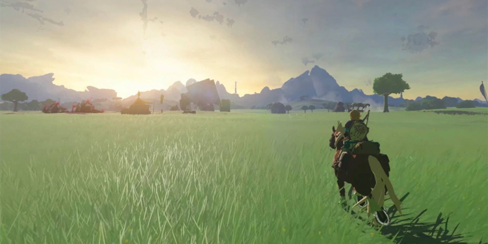 Link riding a horse through an open field of green grass with a sunset