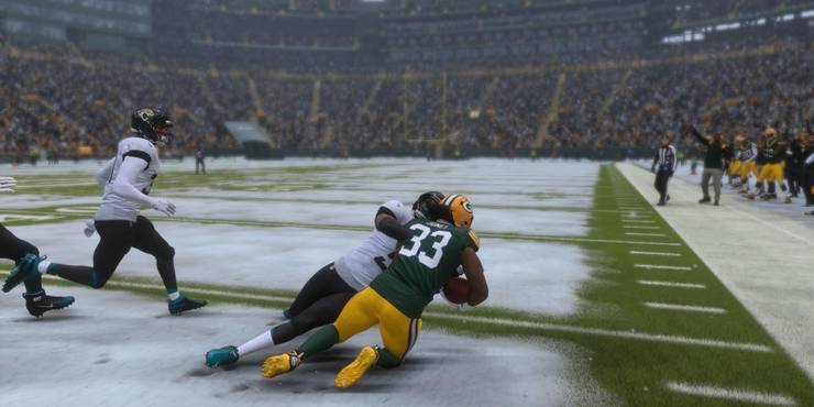 Aaron Jones reaching for more yards as he is being tackled
