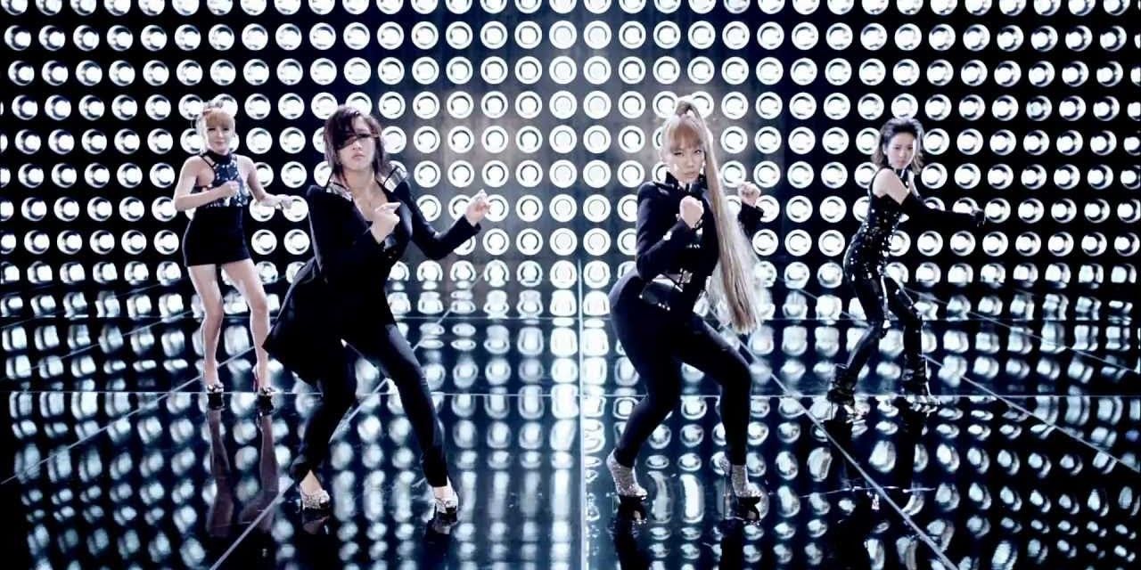 K-pop group 2NE1 dancing against a wall of lights in their music video for I Am The Best