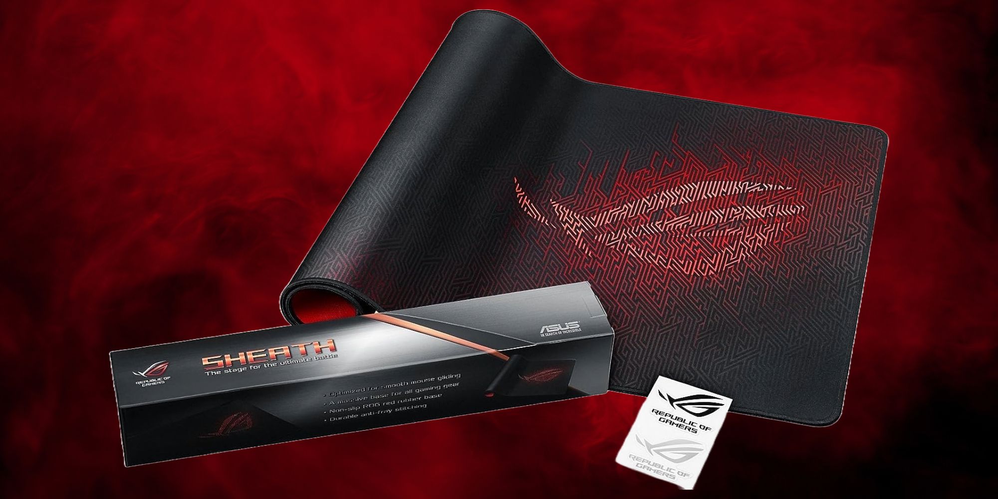 A black and red cloth mousepad with its box and manual against a red smoky backdrop. The box reads 