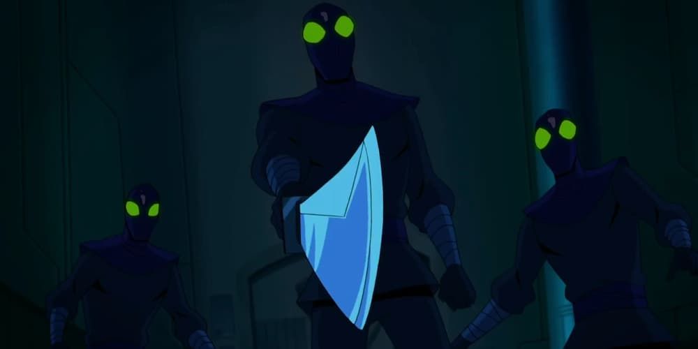 Three members of The Foot Clan stand in a corridor, with one holding a sword, in Batman vs. TMNT.