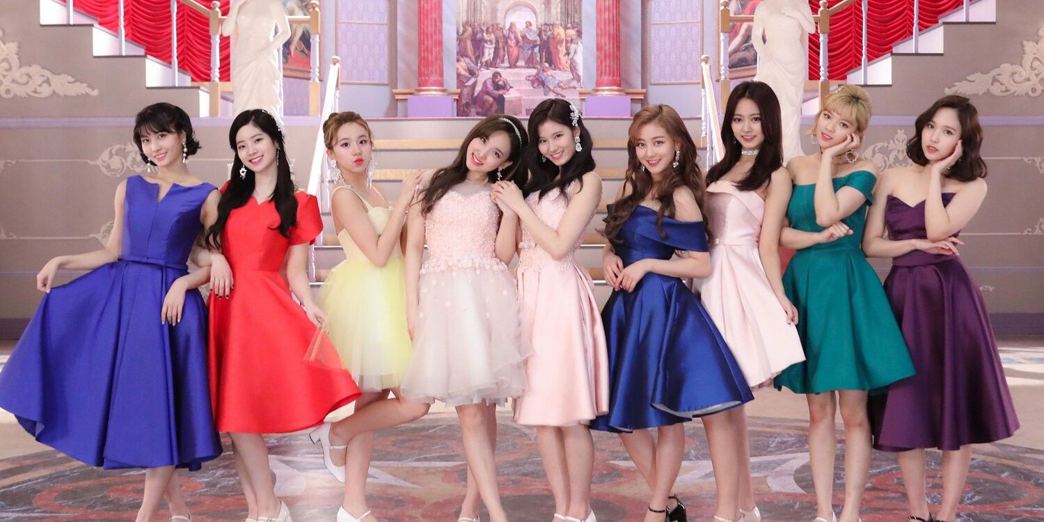 K-pop girl group Twice posing in party dresses in a promotional image for their song What Is Love?