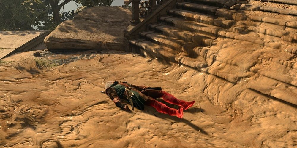 Astarion lying prone in grease at the bottom of a flight of stairs in Baldur's Gate 3