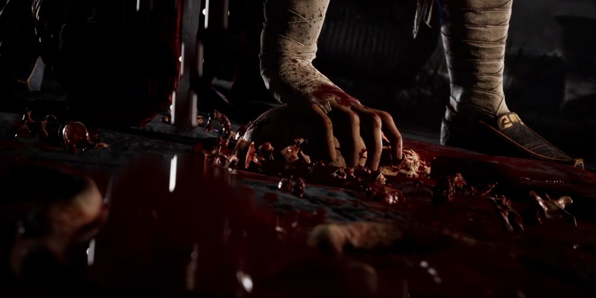 A shot of Liu Kang's bloody hand holding down the smushed head on the arena ground after completing the fatality.