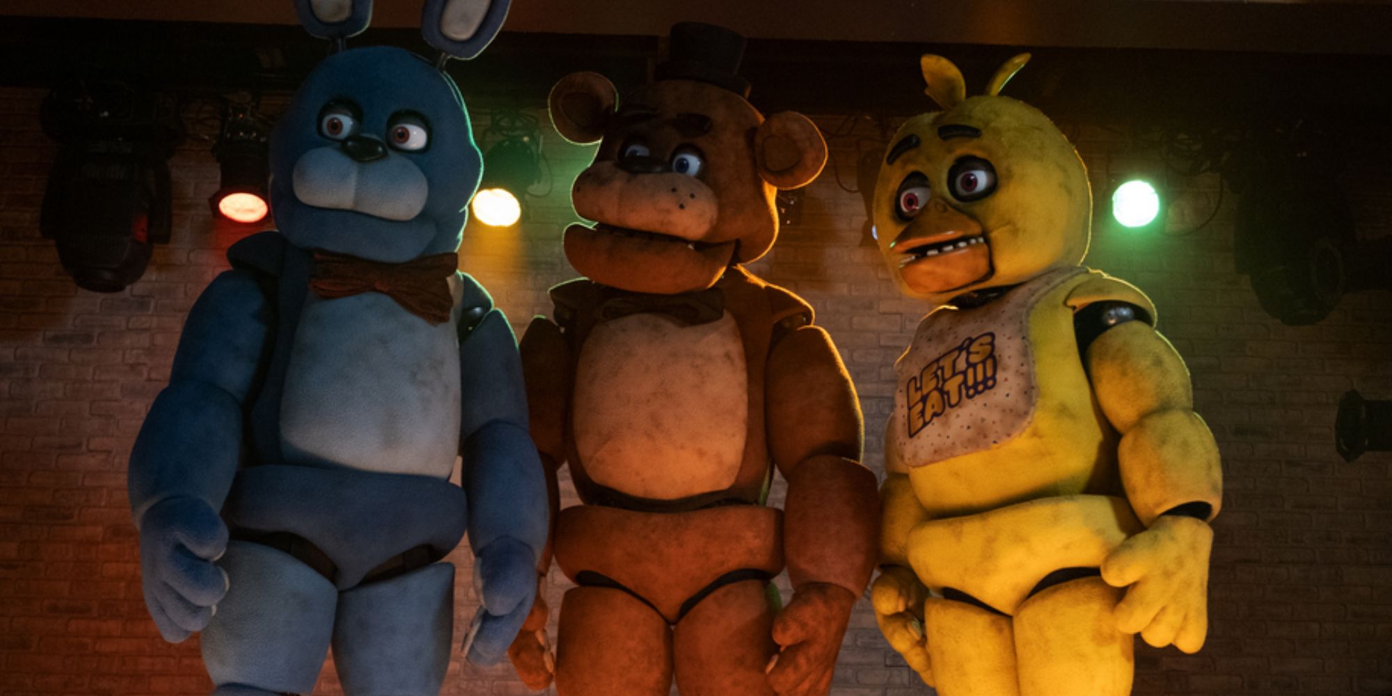 Five Nights At Freddies animatronics stood on a stage looking off the to the left