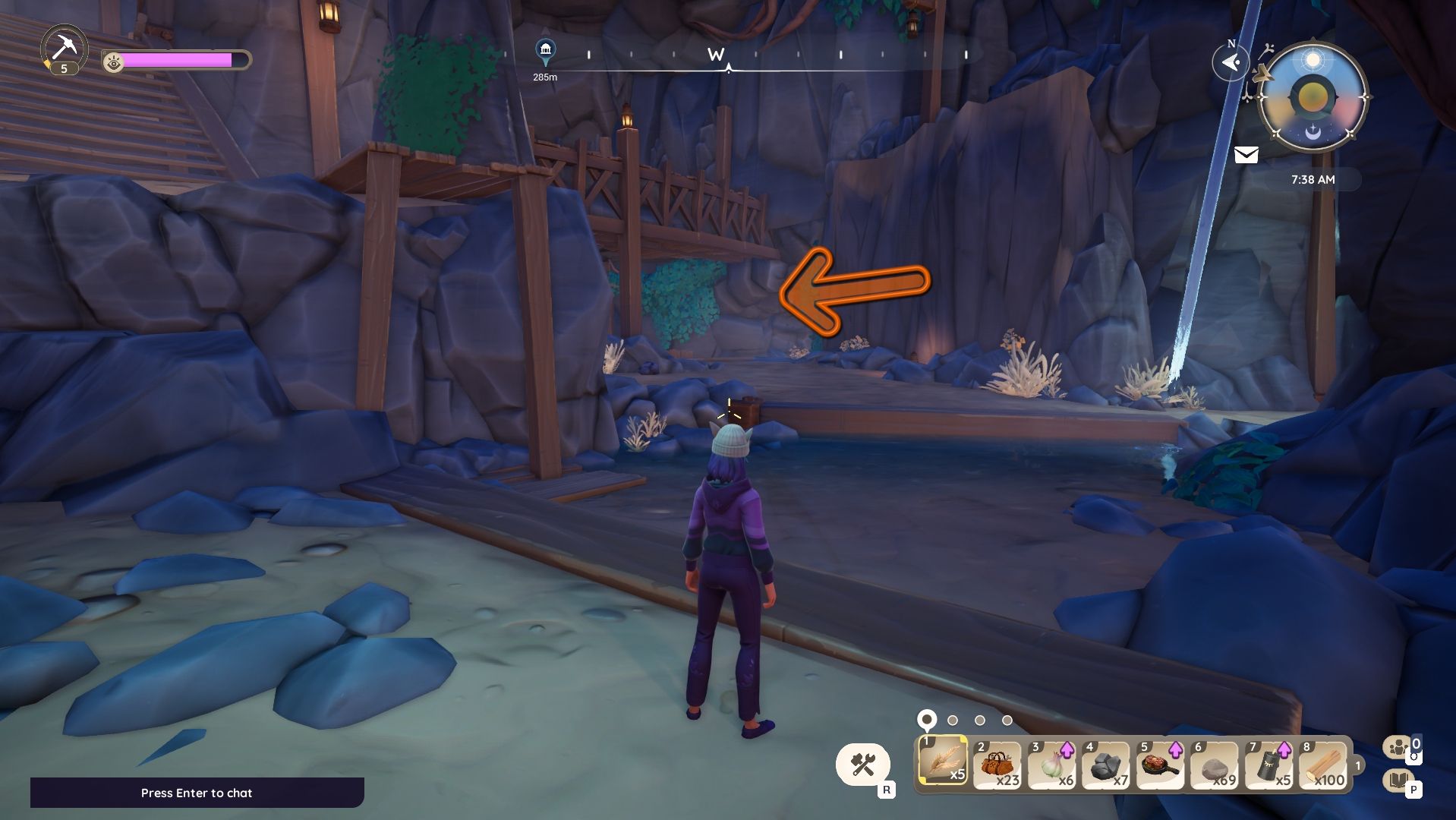 Palia Pavel Mines with an avatar standing in the mines, and an orange arrow pointing the way to a fishing spot. The spot is beyond the wood-reinforced overhang.