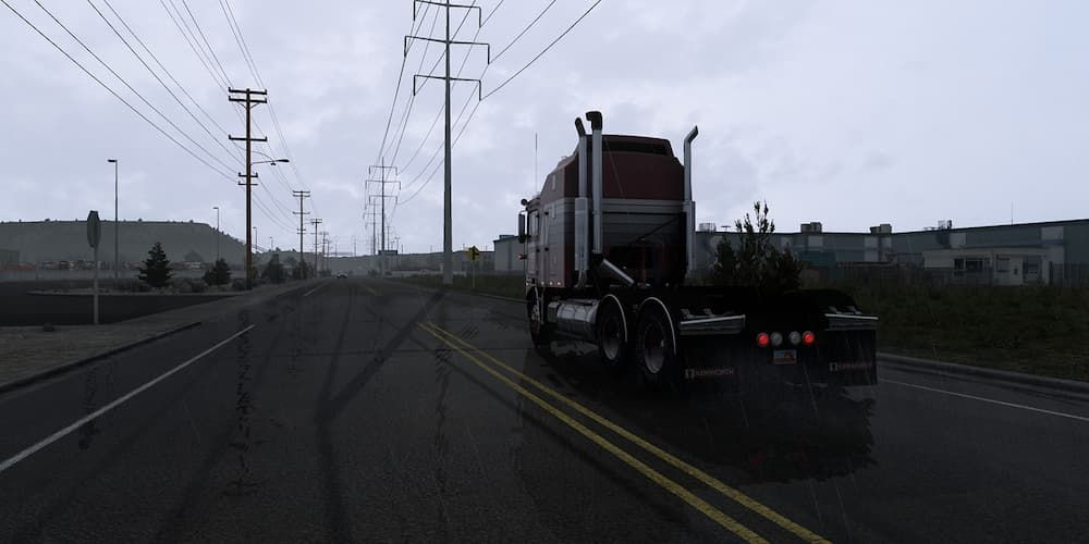 A truck drives in the rain with the Realistic Rain mod for American Truck Simulator.