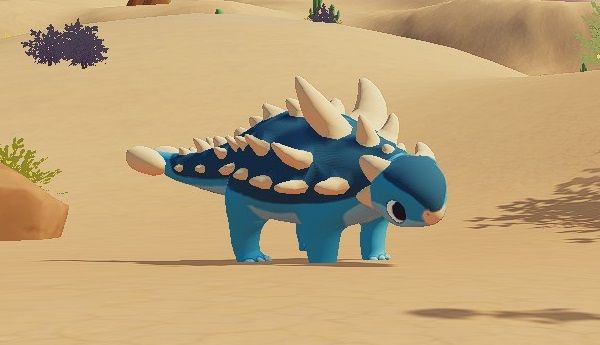 Blue and light blue Euoplocephalus with beige spikes standing in Ariacotta Dunes near a rock during the day in Paleo Pines.