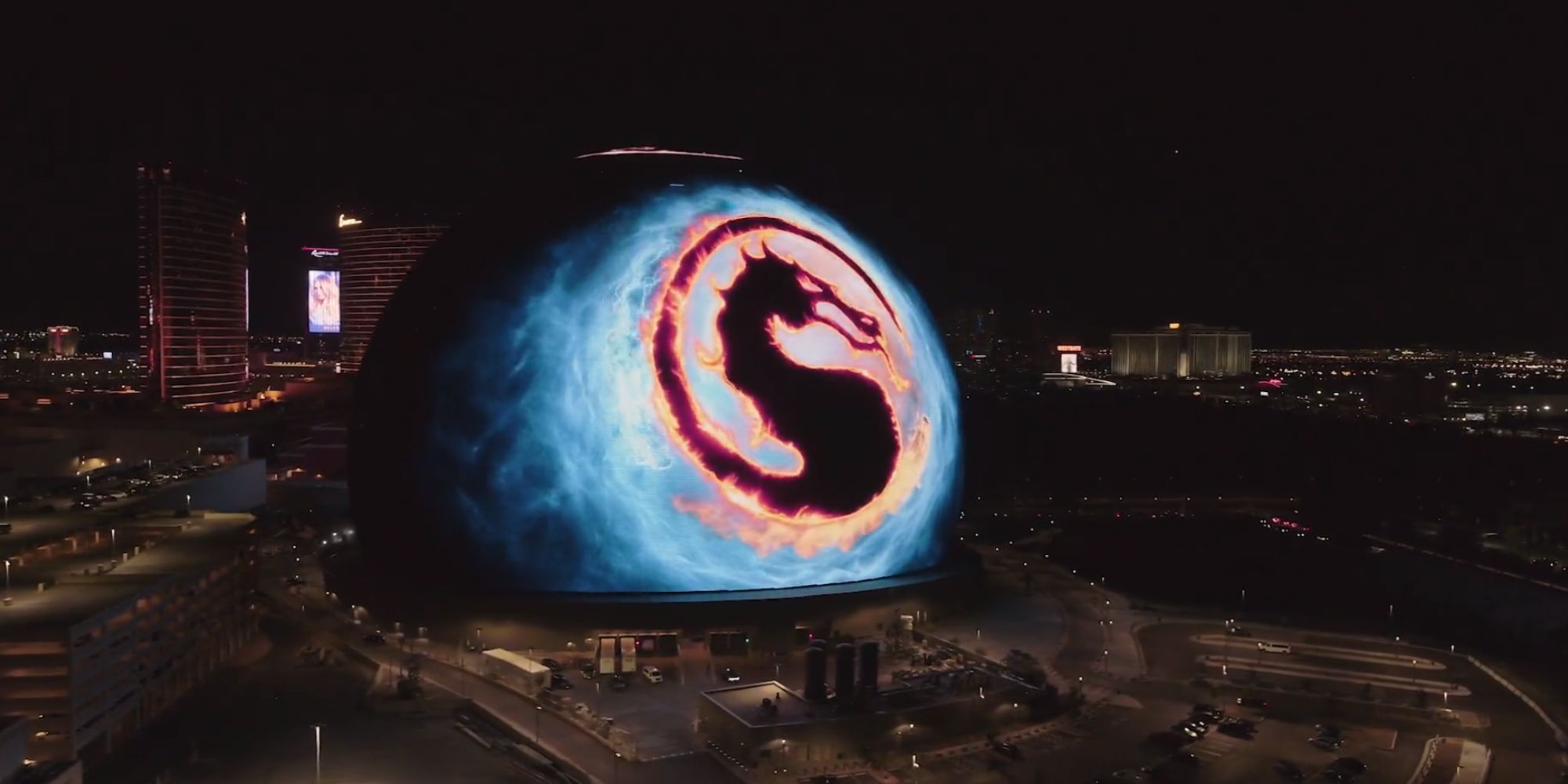 An advert for Mortal Kombat 1 on the MSG Sphere stadium. The stadium is a huge sphere that can display massive adverts. The advert shows the Mortal Kombat logo off to the city. 