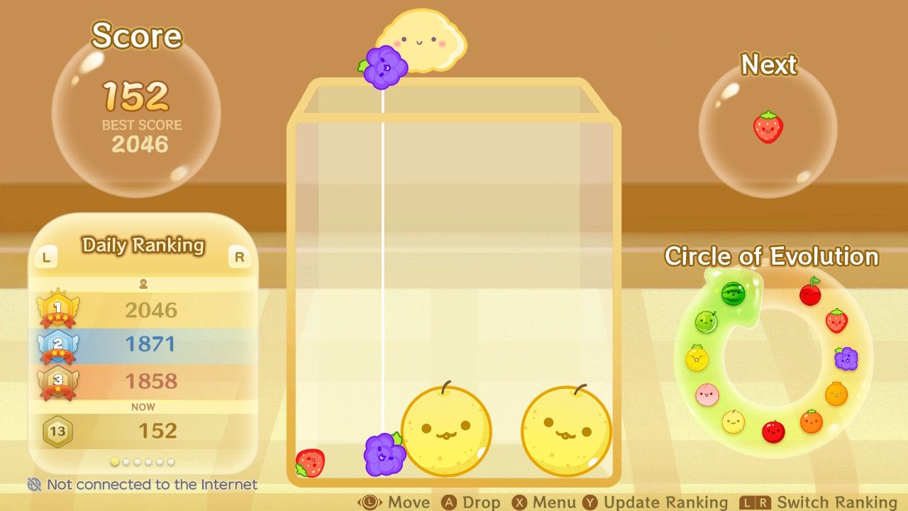 The start of Suika Game, with only four fruit on the board with another grape being placed.