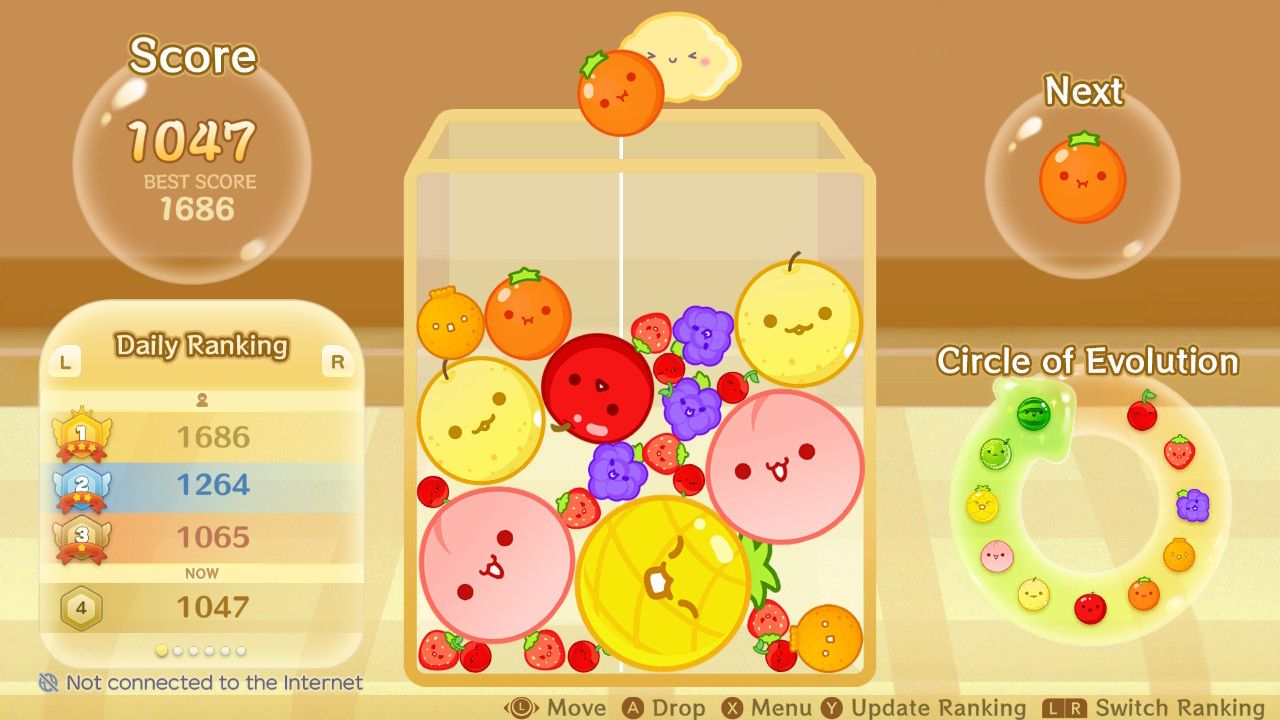 The orange is ready to drop and combine with another orange followed by an apple in Suika Game.