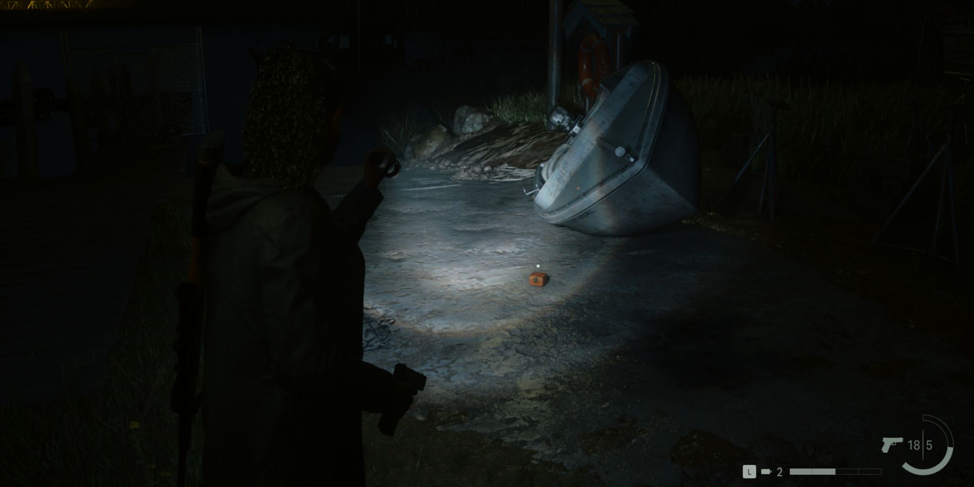 the anchor charm in billie's boat yard, illuminated by a flashlight at night, in Alan Wake 2