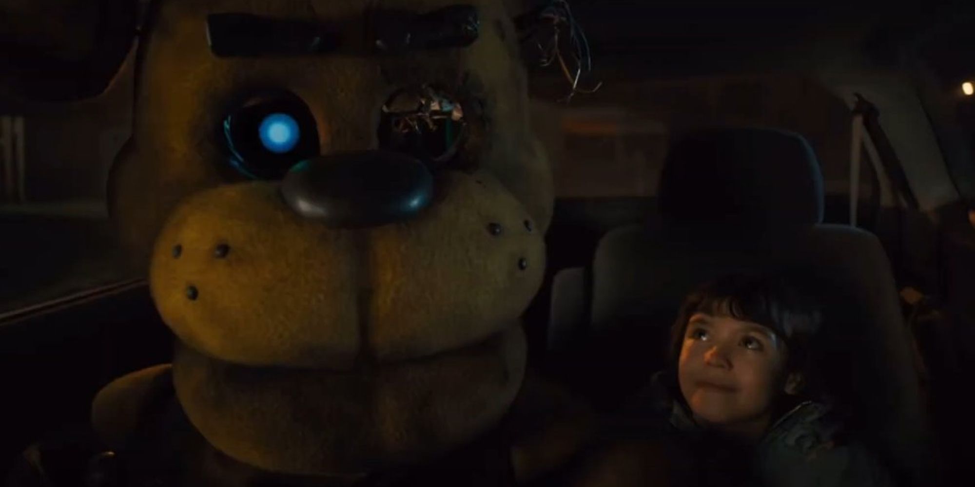 Five Nights at Freddys movie Max sitting in the back of a car with Golden Freddy, who's left eye is missing