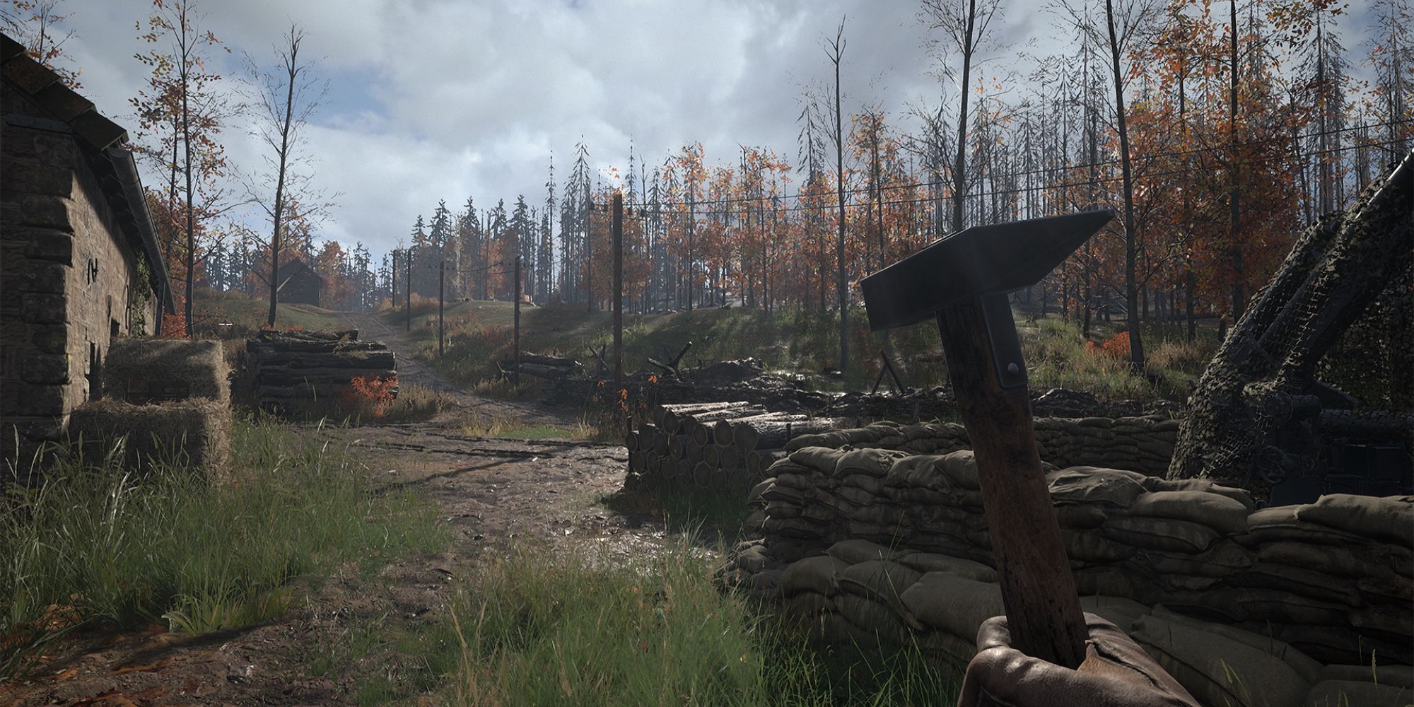 player wielding a hammer looking out and sandbags and autumnal forest
