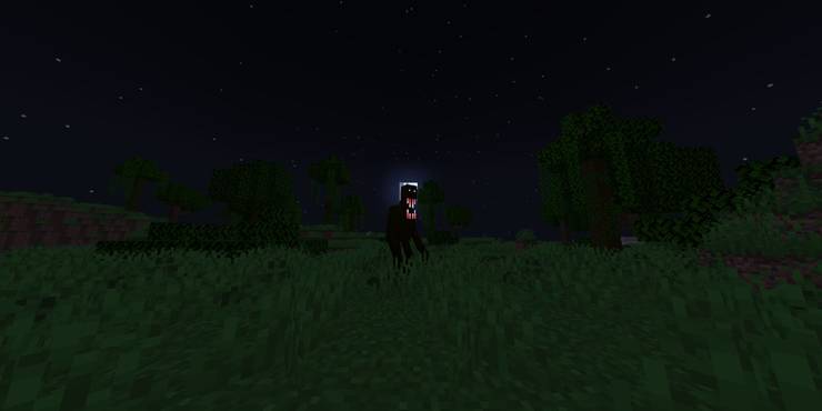 A grassy environment at night, with a tall, black, humanoid figure with a large mouth.