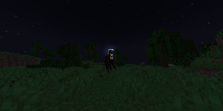 A grassy environment at night, with a tall, black, humanoid figure with a large mouth.
