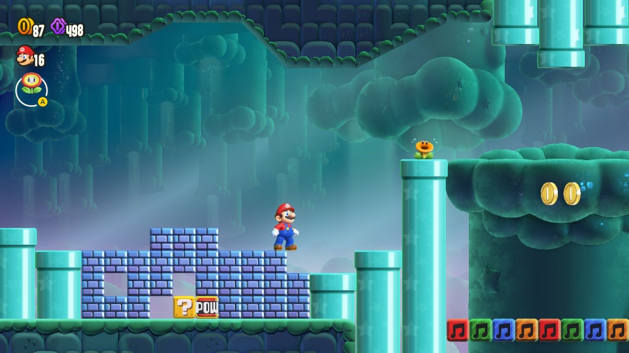Mario standing on brick blocks with a POW block below. There is a much taller pipe with a flower on it to his right.