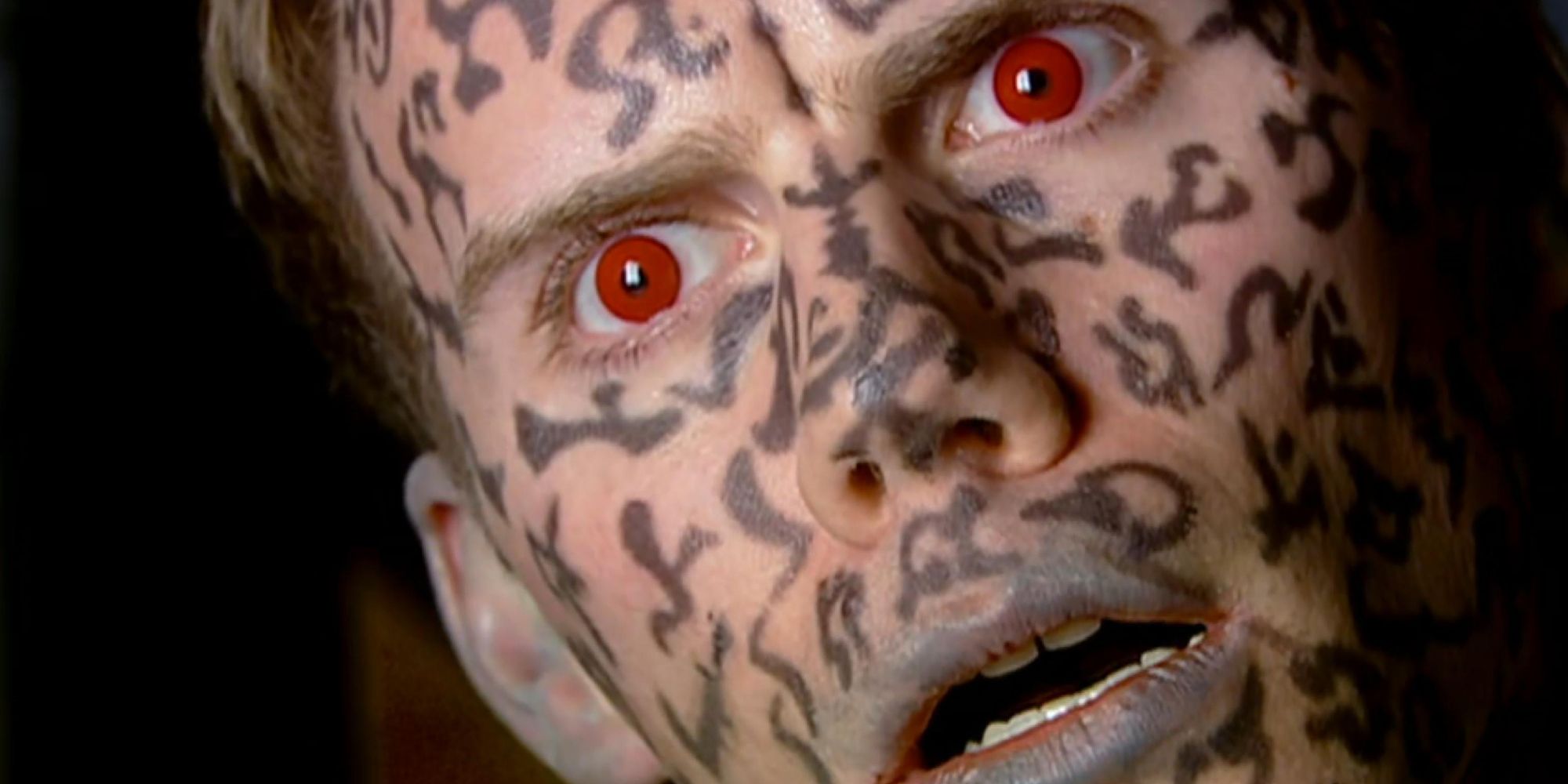 Toby with red eyes and demonic markings over his face in Doctor Who's The Impossible Planet