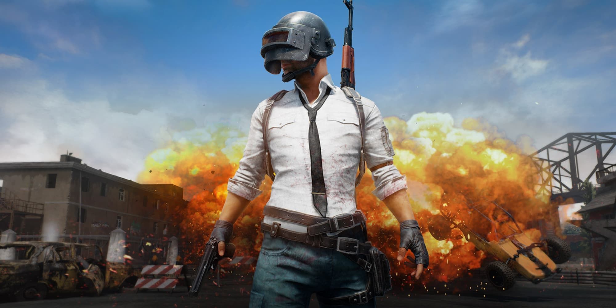 A man stands with a pistol in front of an explosion in PUBG Mobile.