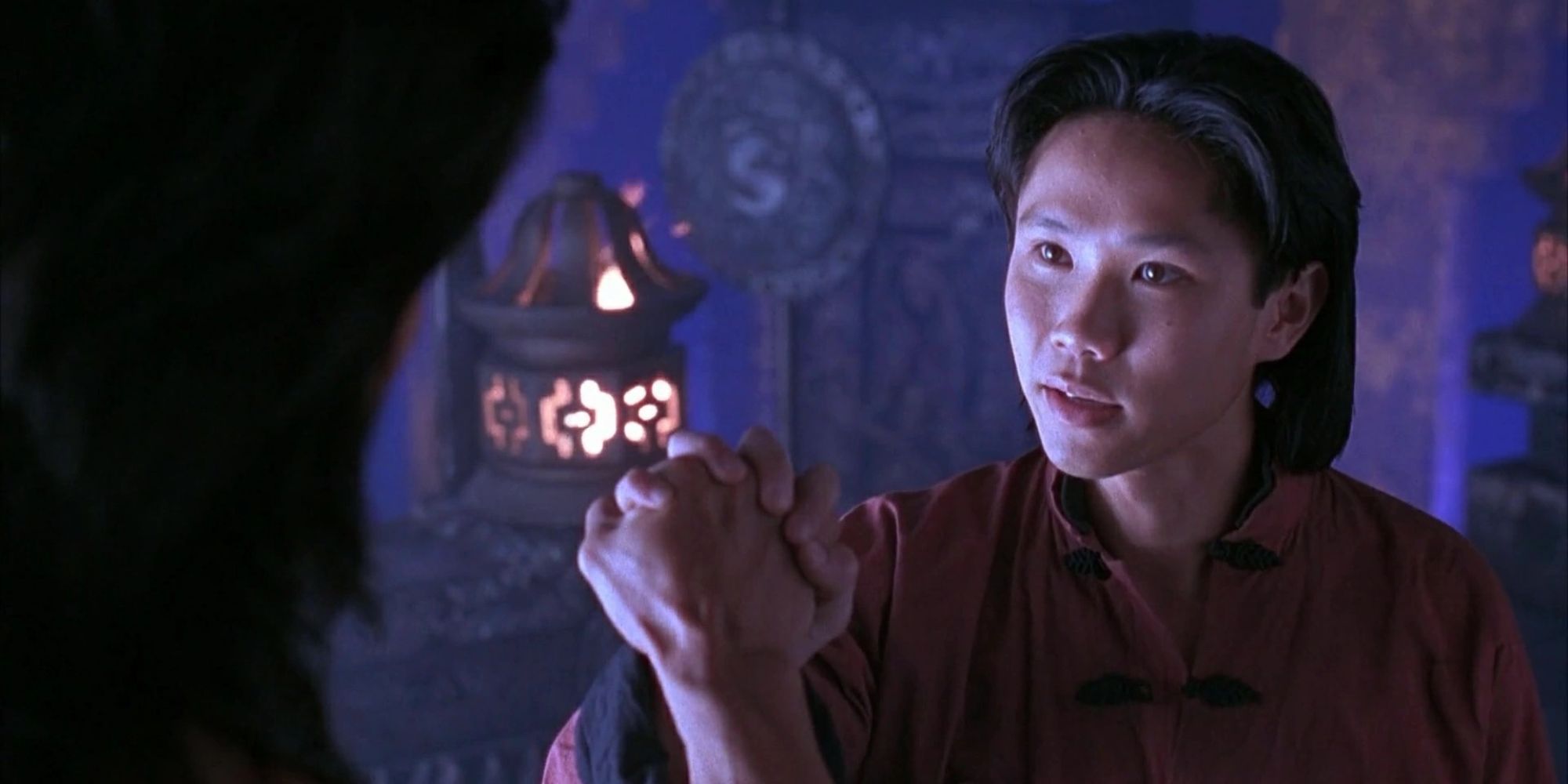 Liu Kang and Chow Kang shake hands in a dark temple