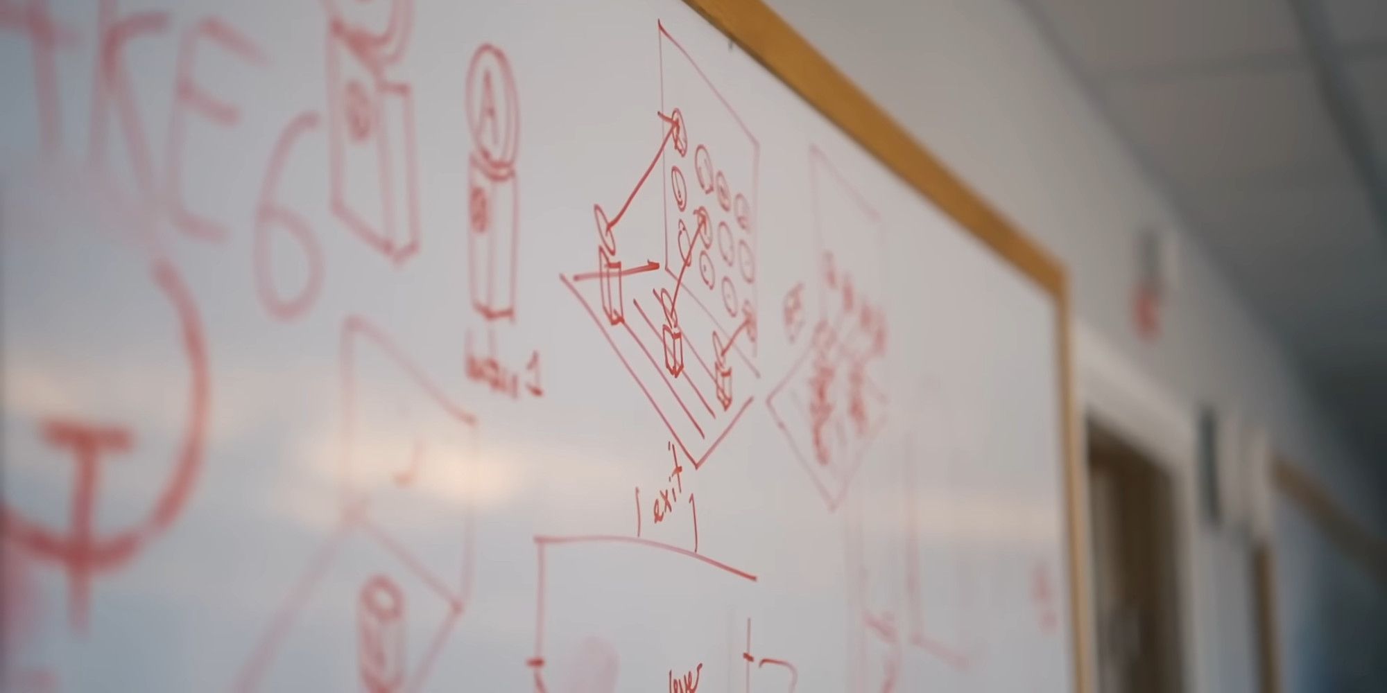 A whiteboard covered in drawings and diagrams, with a quake logo on the left half of the board
