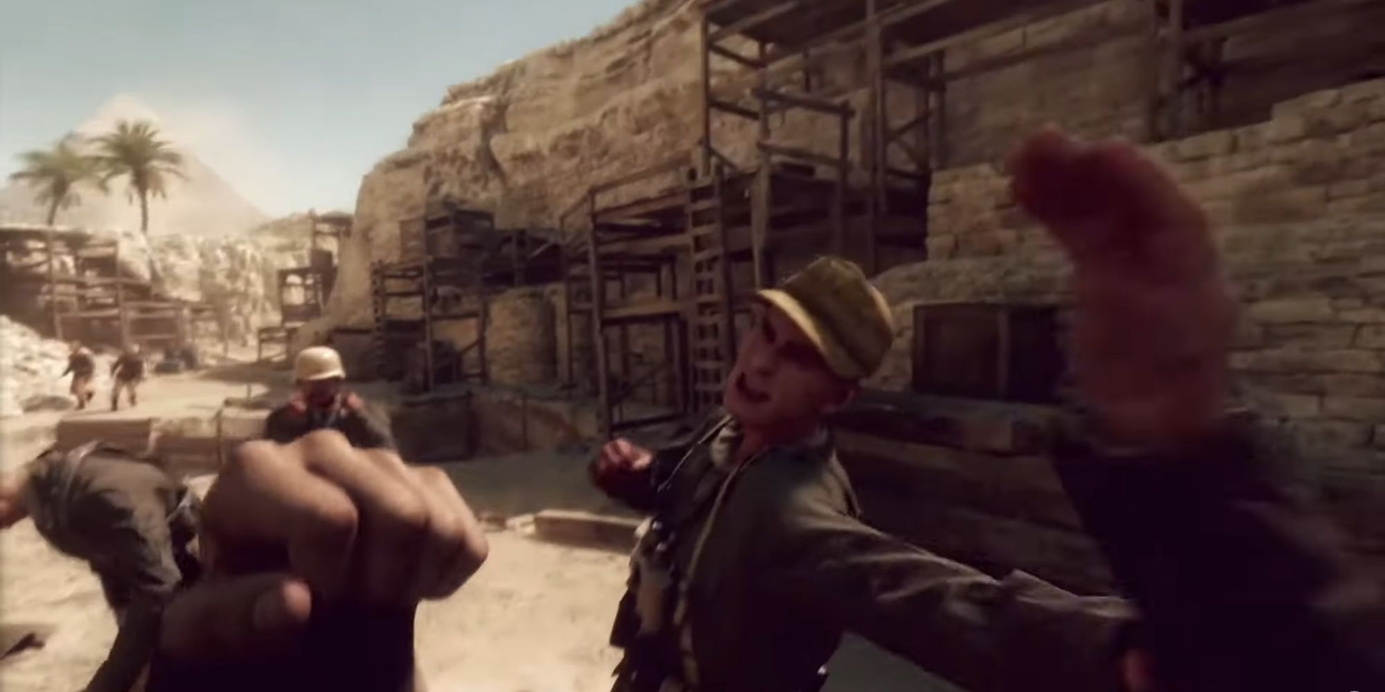 Indy blocking a punch from a soldier in the first-person, fist ready to punch back, and more enemies coming his way.