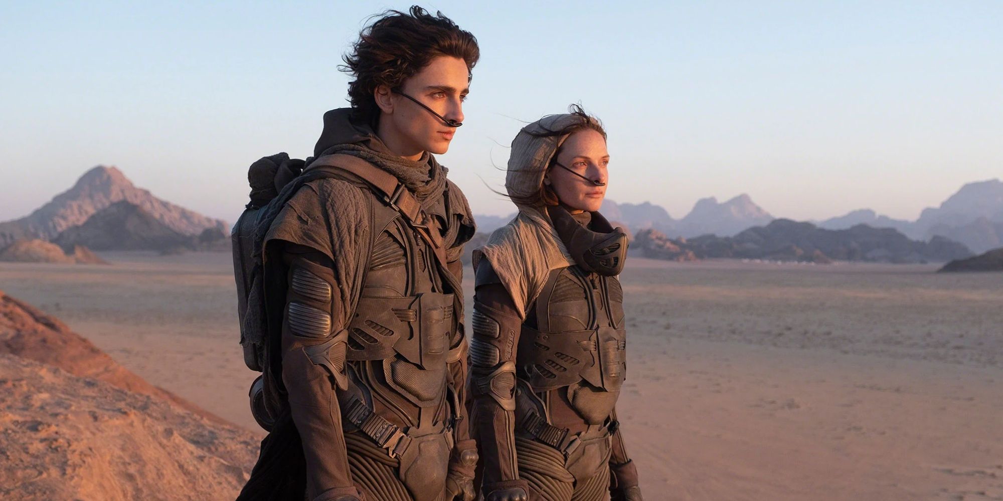 Paul Atreides and Lady Jessica stand in the desert on Arakkis.