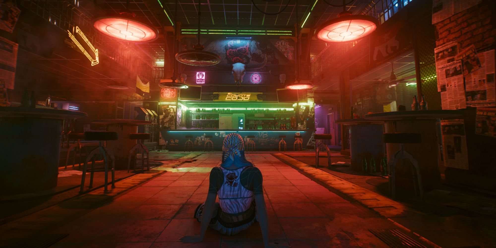 Female V sits on the floor in the empty El Coyote Cojo bar in Cyberpunk 2077