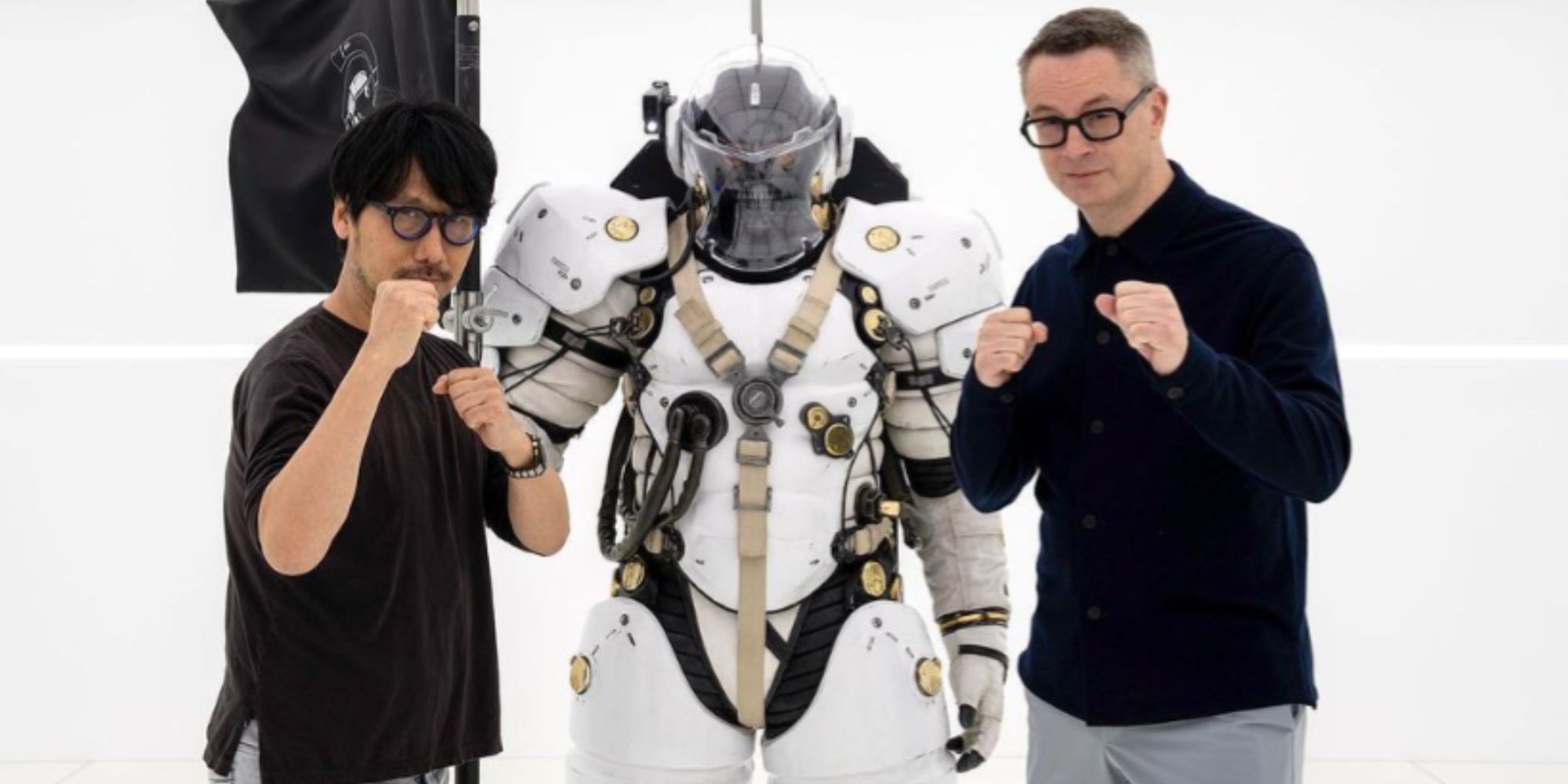 Nicolas Winding Refn is holding a fist standing between Hideo Kojima and KP Ludens mascot.