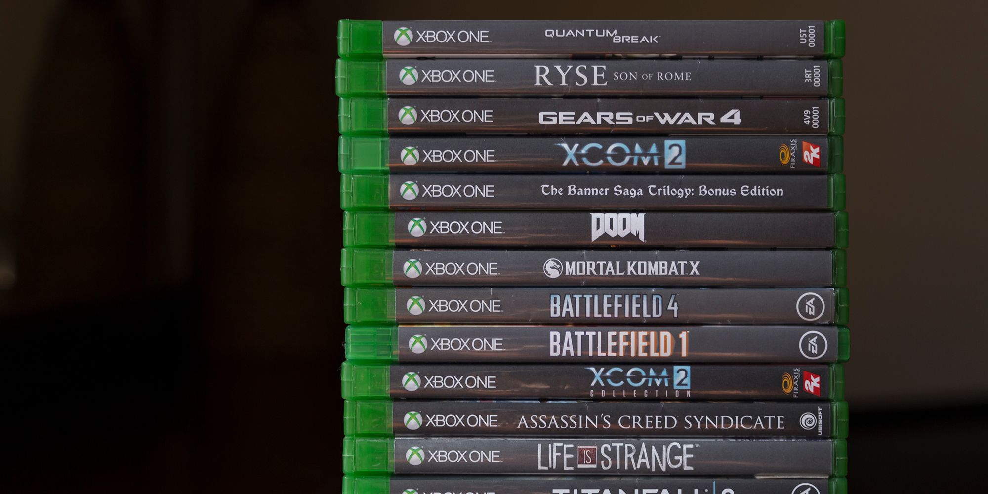 Stack of Xbox One games. From top to bottom: Quantum Break, Ryyse, Gears of War 4, XCOM 2, The Banner Saga Trilogy, DOOM, Mortal Kombat X, Battlefield 4, Battlefield 1, XCOM 2 Collection, Assassin's Creed Syndicate, Life is Strange, Titanfall 2