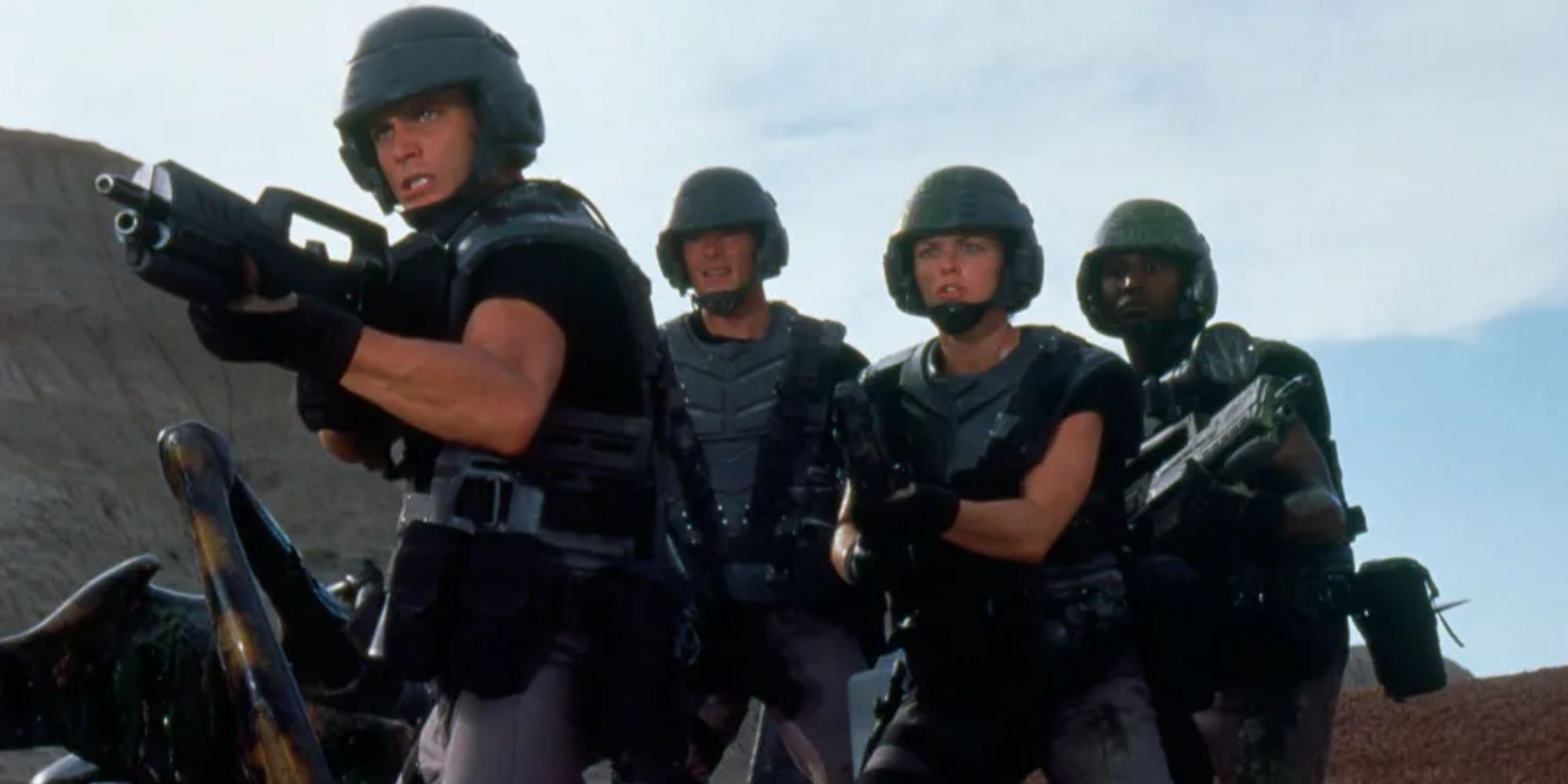 A squad of soldiers on an arid planet stand ready to battle against giant bugs in Starship Troopers.