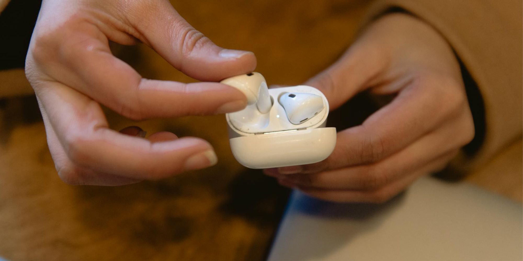 Person Holding AirPod Case And Removing Airpod-1