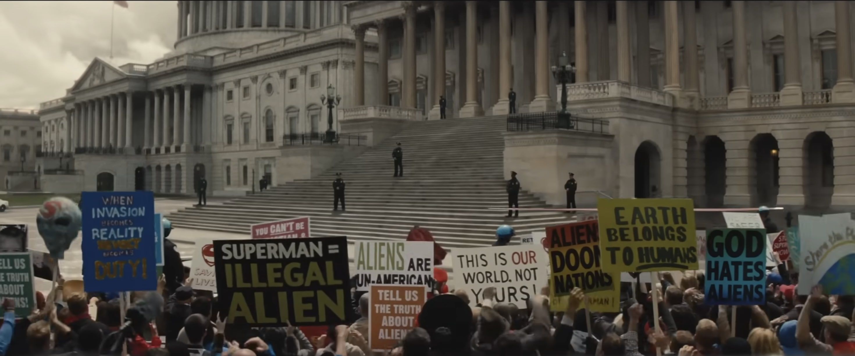 A screenshot of various anti-Superman posters in a scene from Batman V Superman: Dawn of Justice