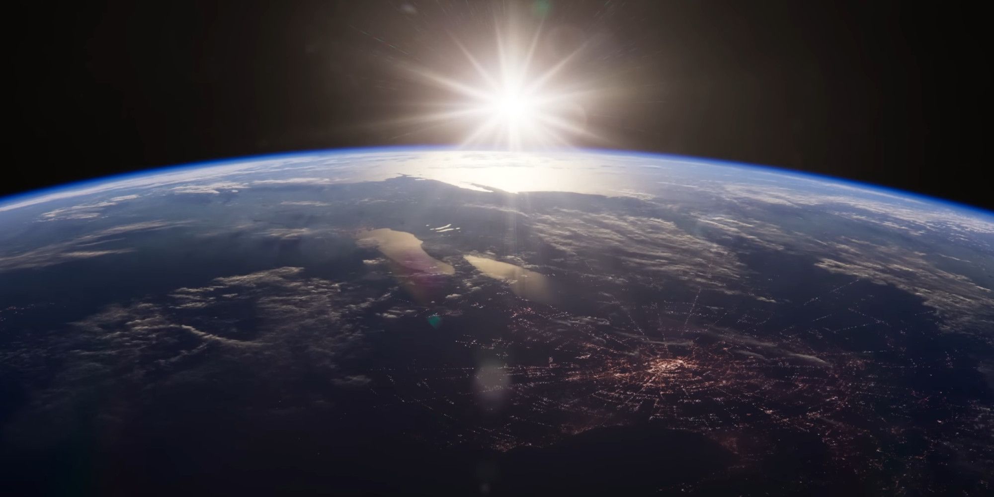 Super Earth from space, with the sun poking out over the horizon of the planet
