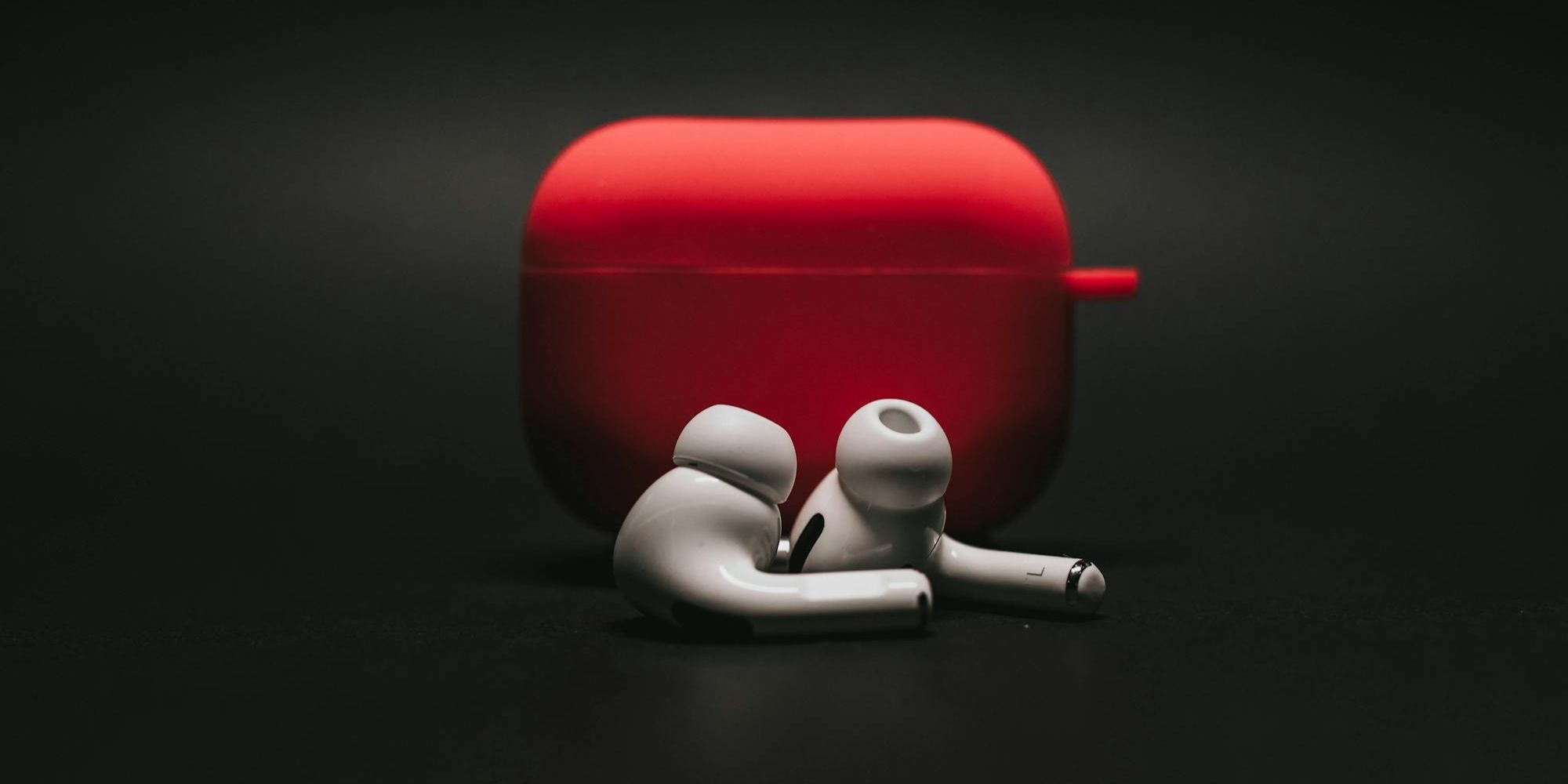 Two AirPods Black Background With Red Case