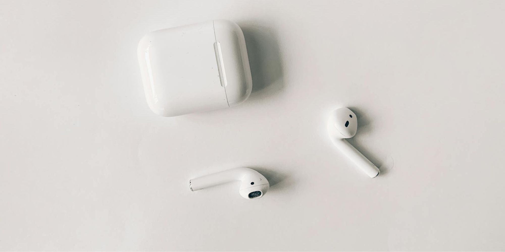 Two AirPods With AirPod Case On White Background