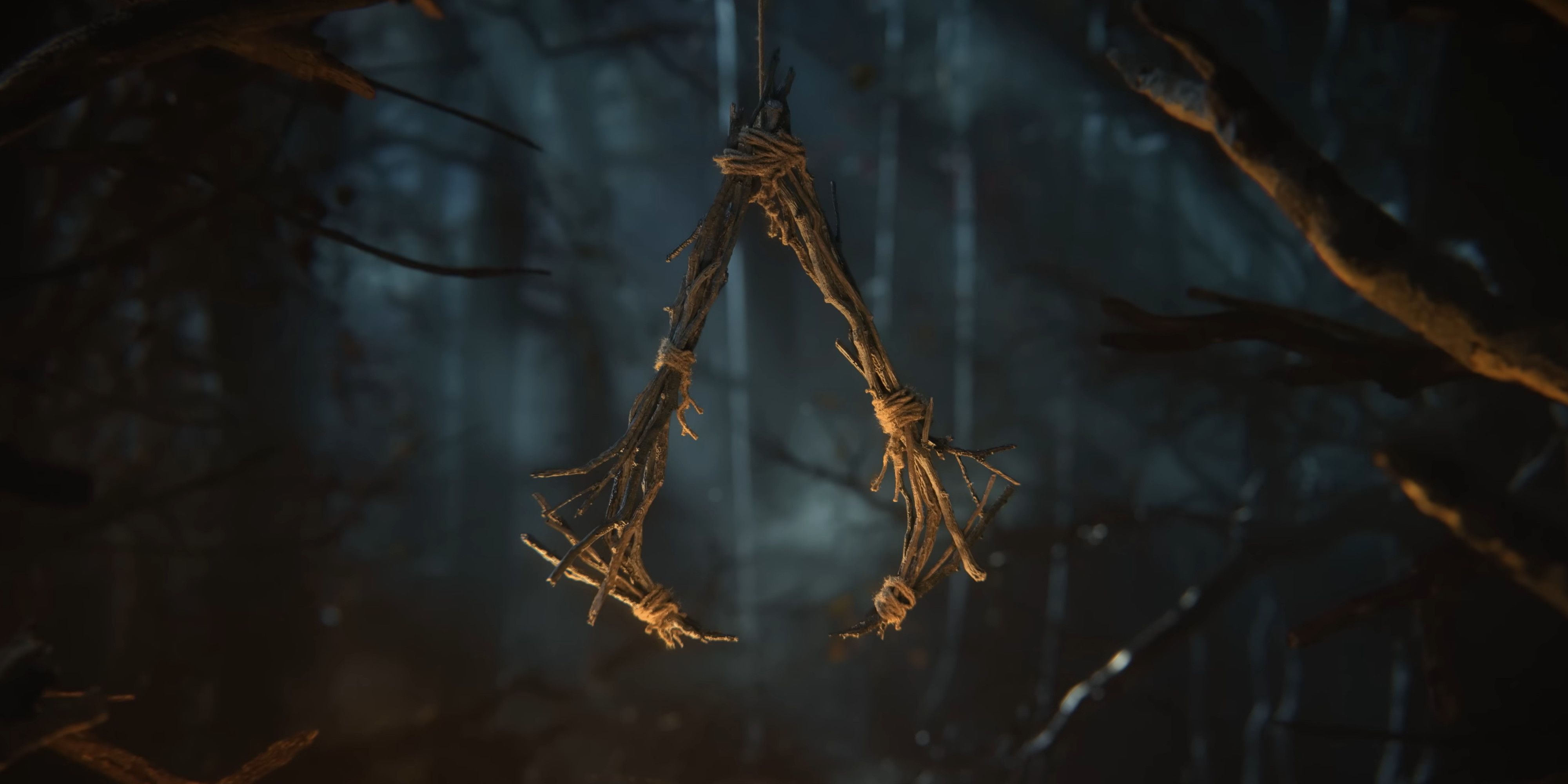 A wooden idol hanging from a tree branch in a dark forest